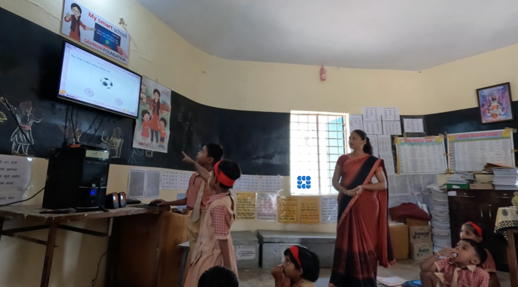 A teacher and student assistant coordinating around the classroom software interface
