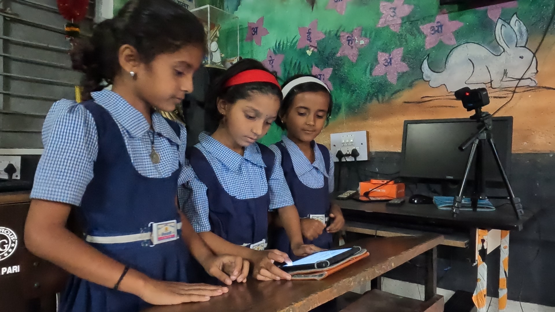 Students interacting with a tablet while being recorded by a camera on a tripod
